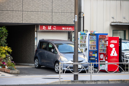 Tokyo, Japan, November 2, 2023: Street view with vending machines and parked car near building entranceのeditorial素材