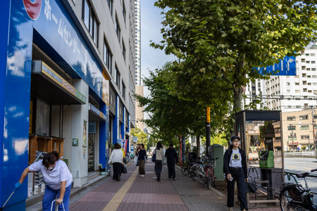 Tokyo, Japan, November 2, 2023: People walking by a Lawson convenience store on a sunny day