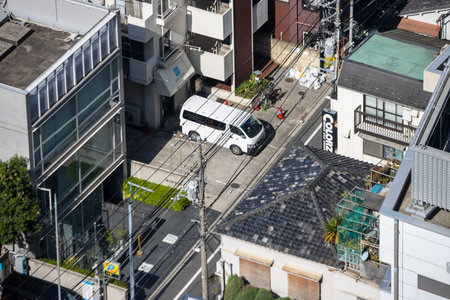 Tokyo, Japan, November 2, 2023: Urban street view with buildings and a parked vanのeditorial素材