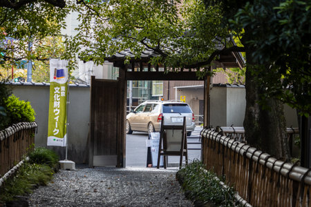 Tokyo, Japan, November 1, 2023: Entrance to a traditional Japanese garden with a view of a city...