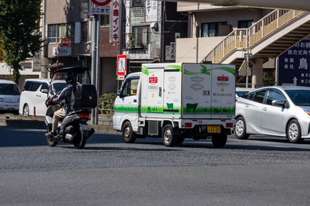 Tokyo, Japan, November 1, 2023: Delivery service motorcycle on the city roadのeditorial素材