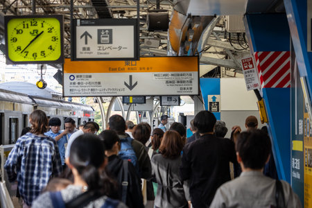 Tokyo, Japan, November 2, 2023: Commuters at Tokyo train station with digital clock displayのeditorial素材