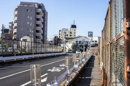 Tokyo, Japan, November 2, 2023: Empty pedestrian lane by the side of a road with city buildingsのeditorial素材