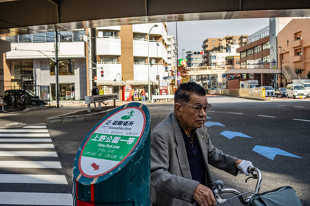 Tokyo, Japan, November 2, 2023: Elderly Man on Bicycle Waiting at Crosswalkのeditorial素材