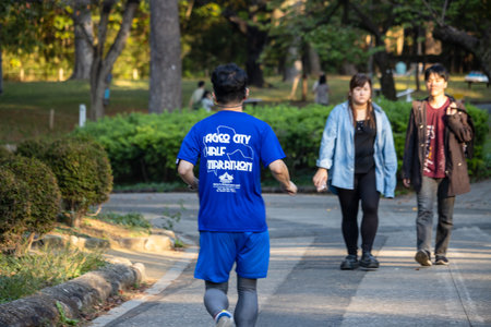 Tokyo, Japan, November 3, 2023: Runner in a blue shirt with event text participates in a triathlon eventのeditorial素材