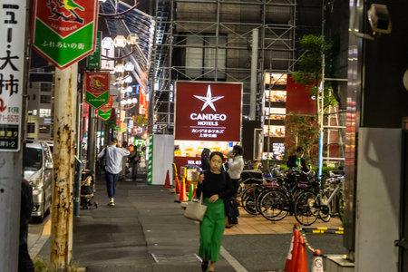 Tokyo, Japan, November 3, 2023: Bustling Street Scene in Tokyo at Night with Pedestrians and Illuminated Signagesのeditorial素材