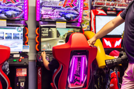 Tokyo, Japan, November 3, 2023: People Playing Arcade Racing Games in Tokyo Game Centerのeditorial素材
