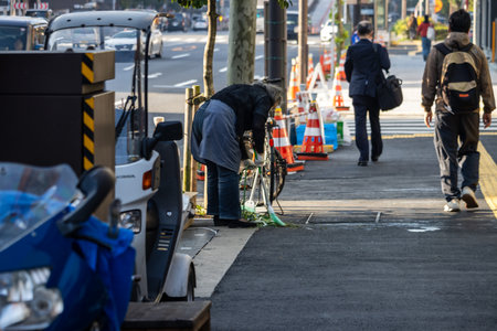 Tokyo, Japan, November 3, 2023: Worker cleaning the sidewalk in a Tokyo streetのeditorial素材