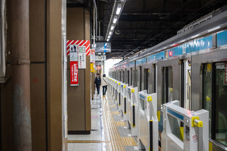 Tokyo, Japan, November 3, 2023: Commuter Exiting Train at a Local Subway Stationのeditorial素材
