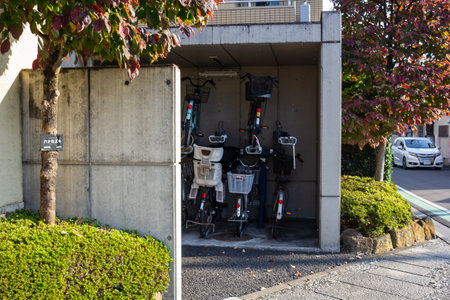 Tokyo, Japan, November 3, 2023: Electric bicycles parked under a residential buildingのeditorial素材
