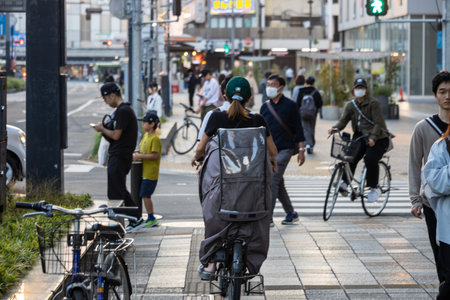 Tokyo, Japan, November 3, 2023: Cityscape with cyclists and pedestrians wearing masks in Taitoのeditorial素材