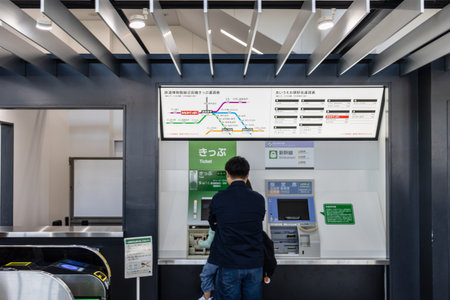 Tokyo, Japan, November 3, 2023: Man interacting with a ticket vending machine in a train stationのeditorial素材