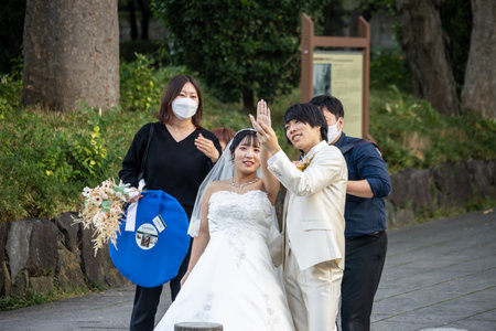 Tokyo, Japan, November 3, 2023: Wedding Photoshoot with Bride, Groom, and Photographer Wearing Masksのeditorial素材