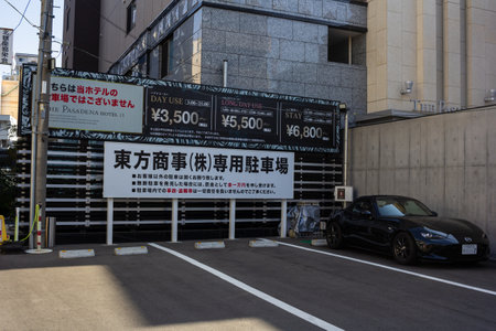Tokyo, Japan, November 3, 2023: Parking lot with posted rates and a luxury car parkedのeditorial素材