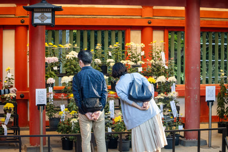 Tokyo, Japan, November 3, 2023: Visitors at a traditional Shinto shrine with floral offeringsのeditorial素材