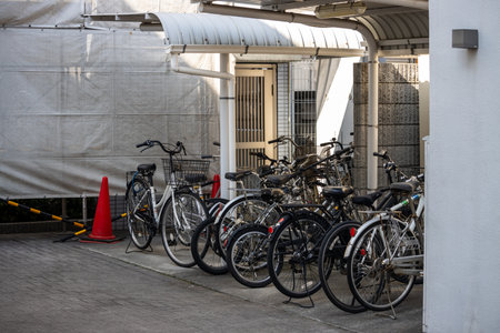 Tokyo, Japan, November 3, 2023: Bicycles parked beside a covered walkway in an urban areaのeditorial素材