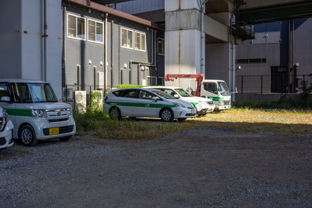 Tokyo, Japan, November 3, 2023: Parked cars and commercial vehicles near industrial buildingsのeditorial素材