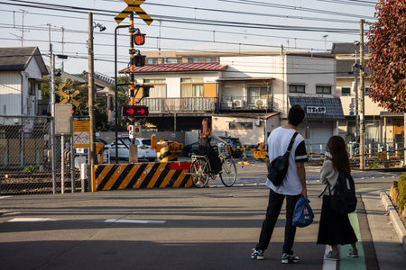 Tokyo, Japan, November 3, 2023: Couple waiting at pedestrian crossing near train stationのeditorial素材