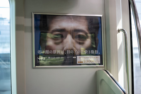 Tokyo, Japan, November 3, 2023: Advertisement in Tokyo train with a man's portraitのeditorial素材