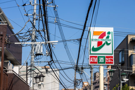 Tokyo, Japan, November 3, 2023: Urban street view with Seven Eleven sign and tangled power lines