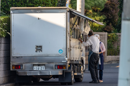 Tokyo, Japan, November 3, 2023: Delivery man at work unloading a white truckのeditorial素材