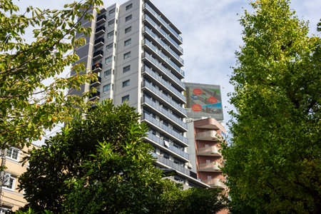Tokyo, Japan, November 4, 2023: Modern Apartment Building with a Vibrant Floral Advertisement Banner in Tokyoのeditorial素材