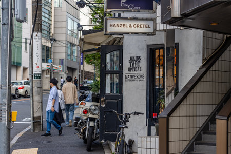 Tokyo, Japan, November 4, 2023: Busy Sidewalk Scene with Motorcycle Parked Outside Hanzel & Gretel,...