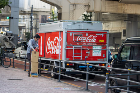 Tokyo, Japan, November 4, 2023: Delivery Worker Unloading Coca-Cola Products from Branded Truck on City Streetのeditorial素材