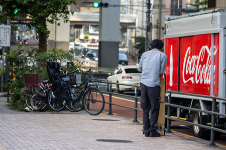 Tokyo, Japan, November 4, 2023: Delivery Worker Loading Coca-Cola Products on a Busy Streetのeditorial素材