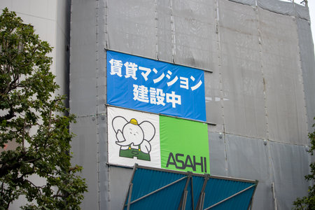 Tokyo, Japan, November 4, 2023: Colorful Asahi Beer Advertisement on Construction Scaffoldingのeditorial素材