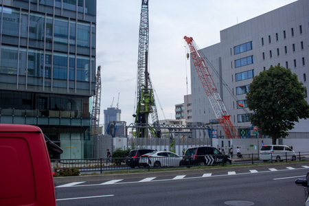 Tokyo, Japan, November 4, 2023: Urban Construction Site with Tower Cranes near Modern Buildingsのeditorial素材