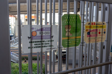Tokyo, Japan, November 4, 2023: Informative Signs Behind Metal Barsのeditorial素材
