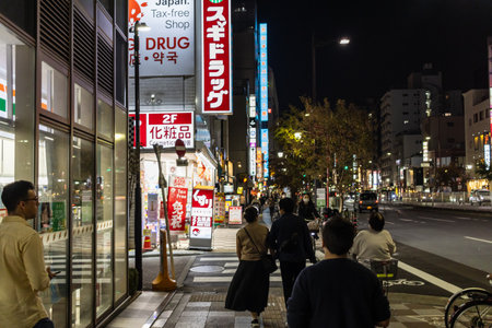 Tokyo, Japan, November 4 2023: Night view of a bustling street with illuminated signs and pedestriansのeditorial素材
