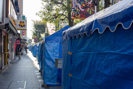 Tokyo, Japan, November 4, 2023: Urban Street Scene with Construction Tarps and Fast Food Outletのeditorial素材