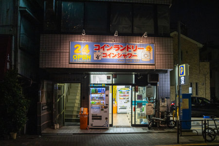 Tokyo, Japan, November 4 2023: Night view of a Japanese laundromat storefront with bright signage