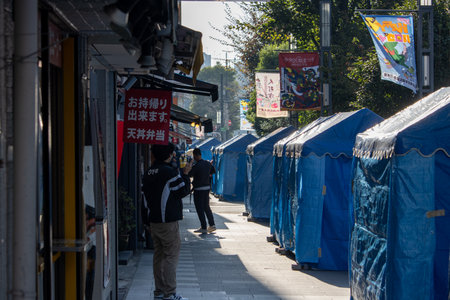 Tokyo, Japan, November 4 2023: Street view with blue market stalls and a photographerのeditorial素材