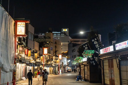 Tokyo, Japan, November 4, 2023: Nighttime Street Scene with Illuminated Signs and Pedestriansのeditorial素材