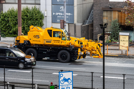 Tokyo, Japan, November 5 2023: Yellow construction crane truck on city streetのeditorial素材