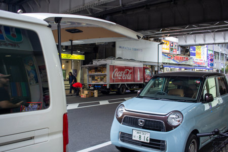 Tokyo, Japan, November 5 2023: Urban Street Scene with Vehicles and Advertisement Billboardsのeditorial素材