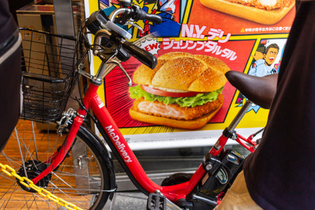 Tokyo, Japan, November 4, 2023: Bicycle parked in front of a fast food advertisementのeditorial素材