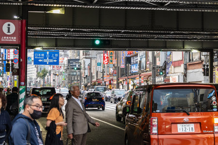 Tokyo, Japan, November 5 2023: Bustling Street Scene with Pedestrians and Traffic Under the Signage-Clad Buildingsのeditorial素材