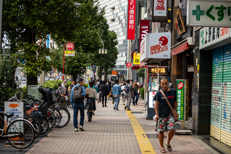 Tokyo, Japan, November 5 2023: Urban Street Scene with Pedestrians and Storefrontsのeditorial素材