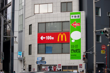 Tokyo, Japan, November 5 2023: McDonald's Signage with Direction Indicator on Urban Buildingのeditorial素材