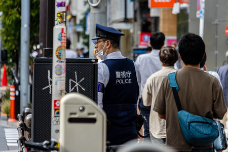 Tokyo, Japan, November 6 2023: Japanese Police Officer on Duty in Busy Streetのeditorial素材