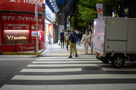 Tokyo, Japan, November 6, 2023: Nightlife scene with pedestrians and storefrontsのeditorial素材