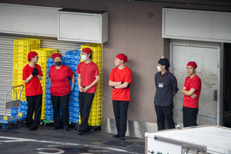 Tokyo, Japan, November 6 2023: Workers in Red Uniforms Standing Outside a Restaurantのeditorial素材