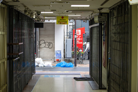 Tokyo, Japan, November 6 2023: Urban Alley with Closed Shops and Money Exchange Signのeditorial素材