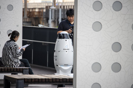 Tokyo, Japan, November 6 2023: A young man operating an autonomous robotic cleaning machineのeditorial素材