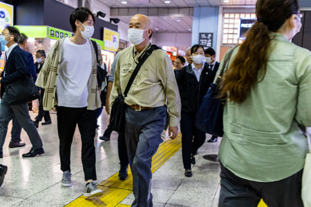 Tokyo, Japan, November 7, 2023: Commuters in subway station with protective masks
