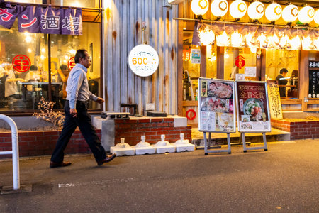Tokyo, Japan, November 7, 2023: Bustling Evening Street Scene with Traditional Restaurantのeditorial素材